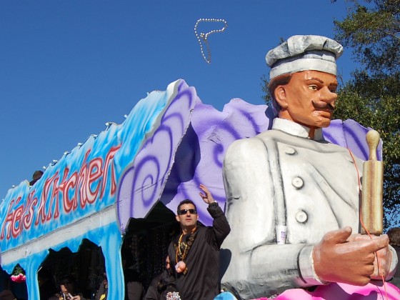 Rider tosses beads from a  'Hell's Kitchen'-themed float